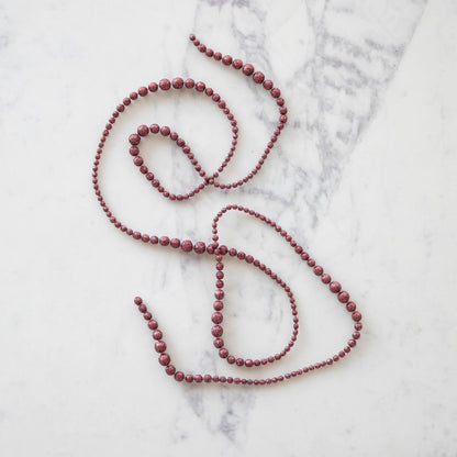 red sparkly ball garland laying on a table