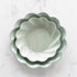 Three sturdy, Sophistiplate Wavy Eco Sage Plates stacked on top of each other.