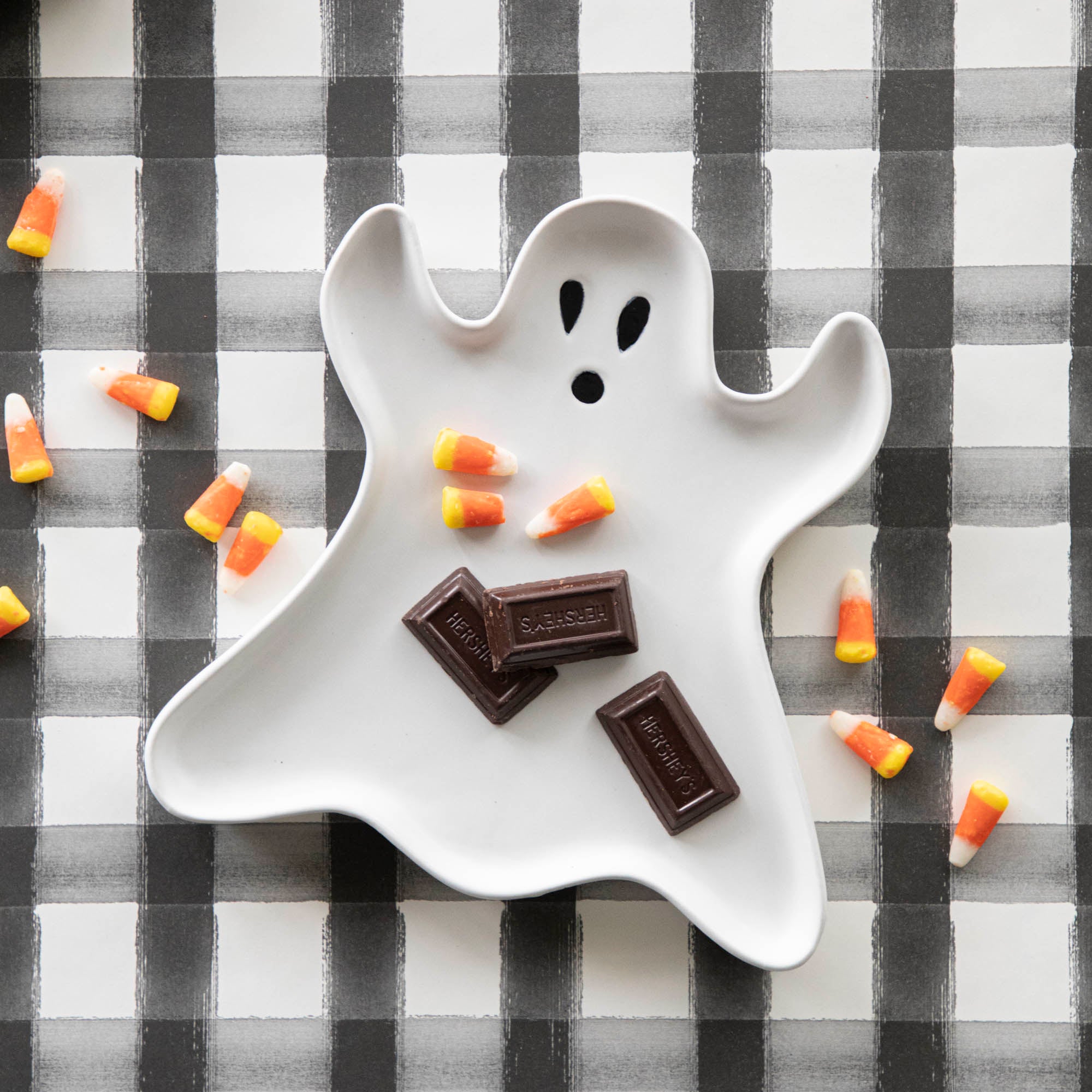 Stoneware Ghost Shaped Plate candy sprinkled across it and the Black Painted Check Runner underneath.