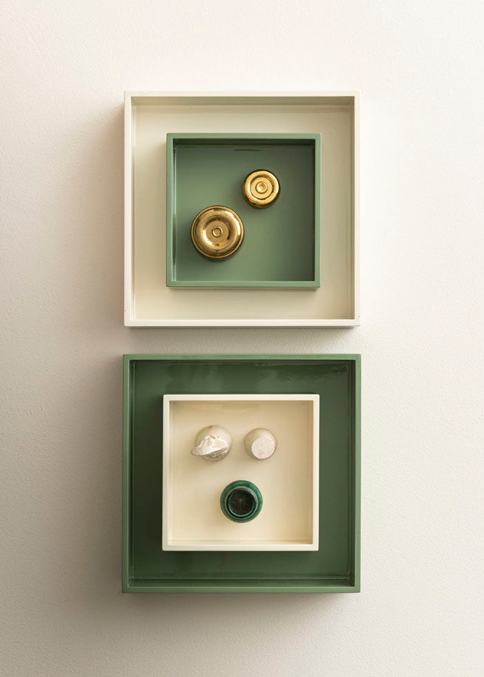Several lacquer boxes nested into each other with small decor pieces inside the smallest boxes on a white background. 