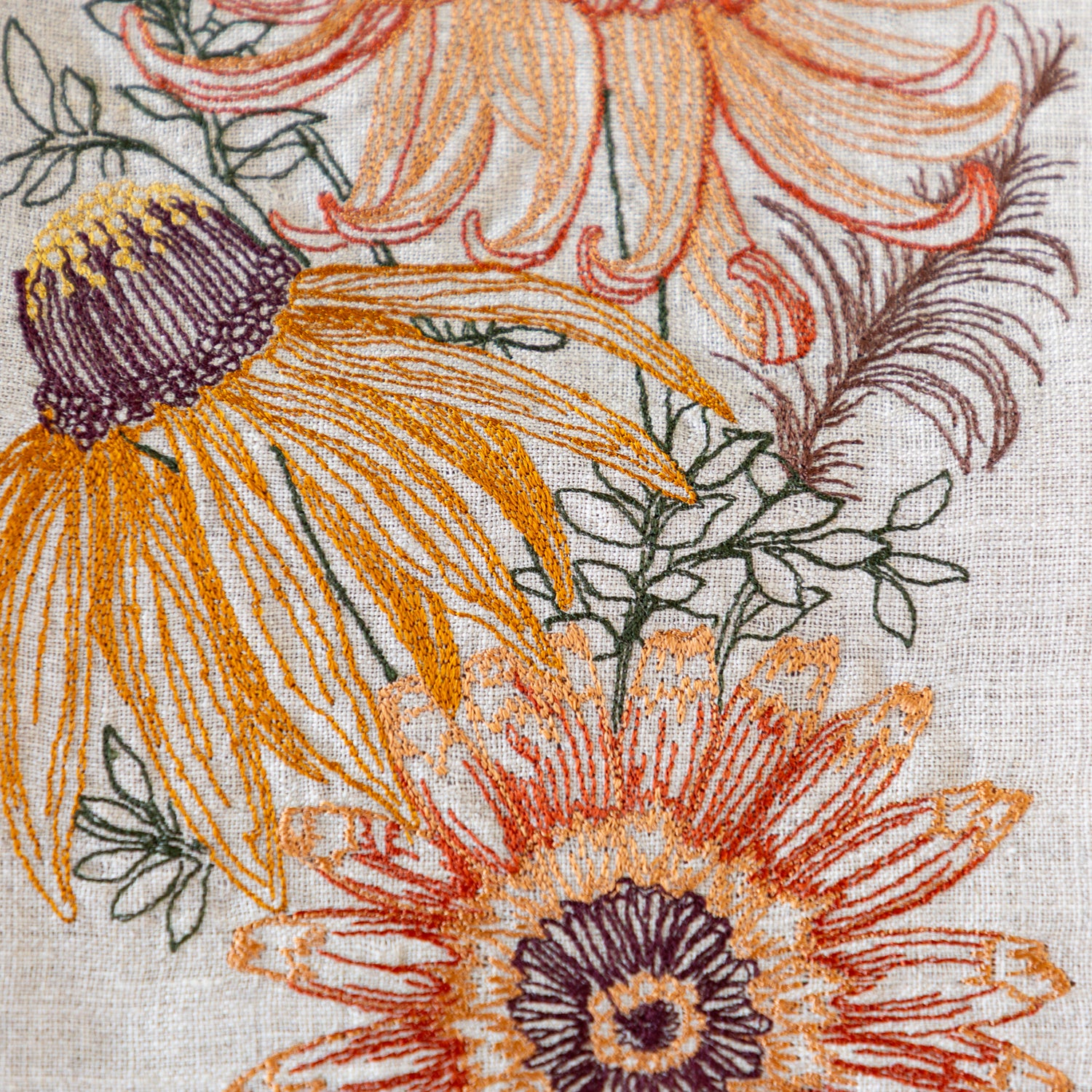Close-up of a floral pattern with orange and purple flowers on a textured fabric background.