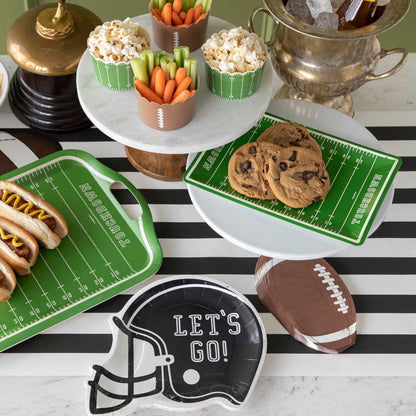 Football themed table setting with various game day snacks.