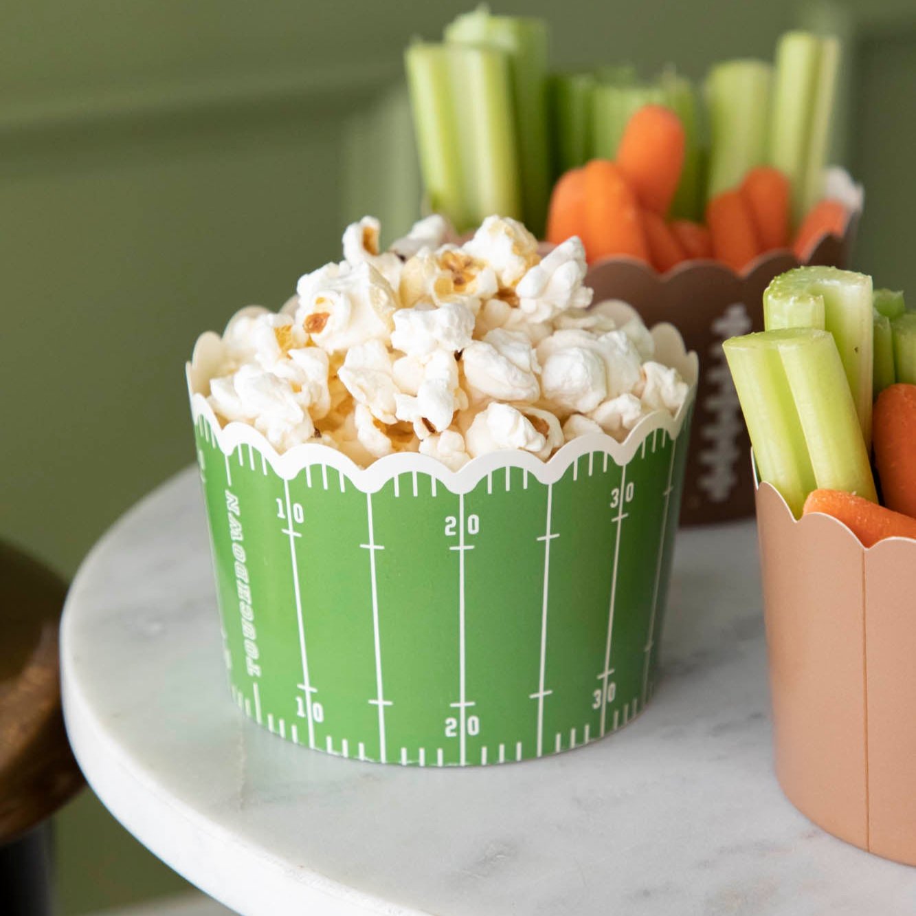 Popcorn inside of a football field paper baking cup.