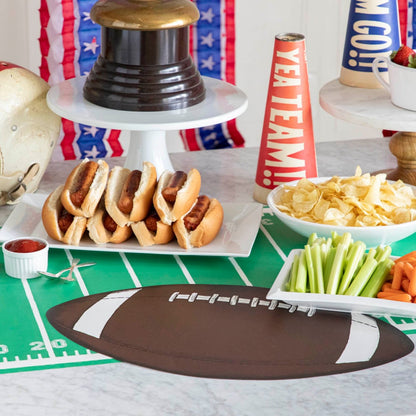 Football placemat on a touchdown football runner, shown on a table with hot dogs, potato chips and sports decor.