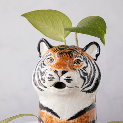 A set of quirky Quail tiger ceramic vases on a wooden table.