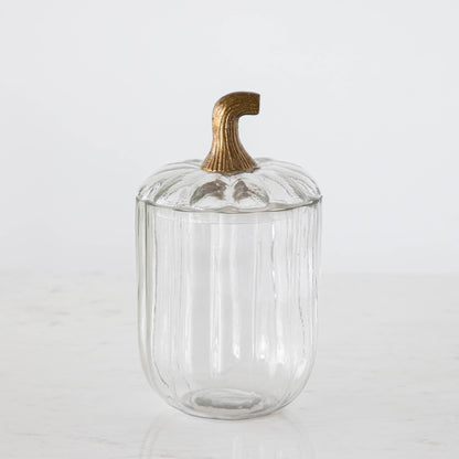 A large Translucent Pumpkin Terrarium with an antique bronze stem lid on a marble table.