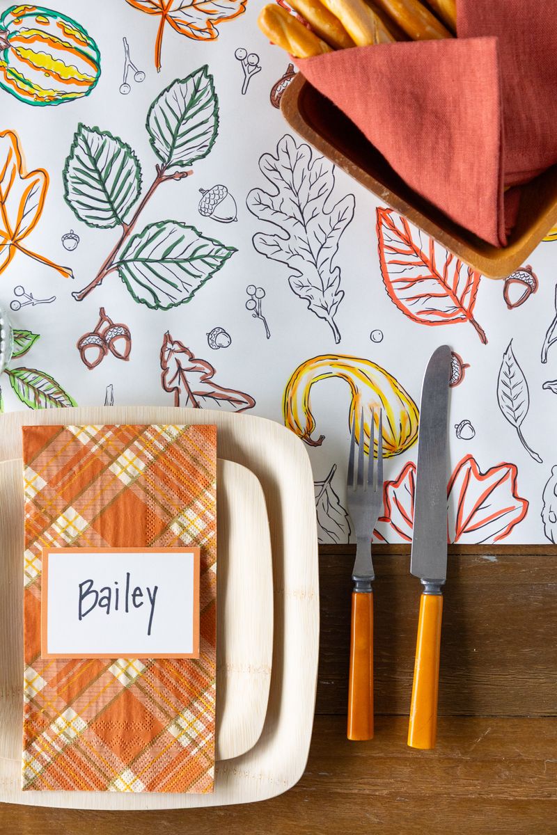 A fall tablescape featuring a partially colored in Autumn Coloring Runner, with colorful markers scattered on the table.