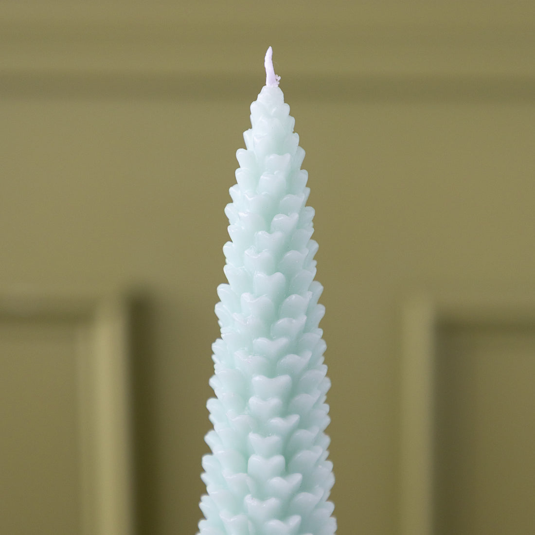 A close up of the Mint Large Pinecone Taper Candle.