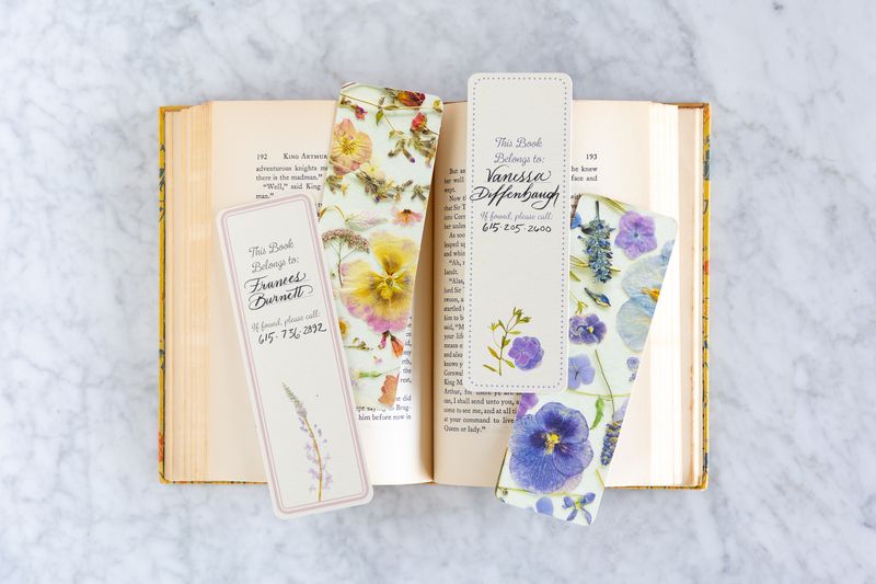 Floral bookmarks on an open book with a gray background