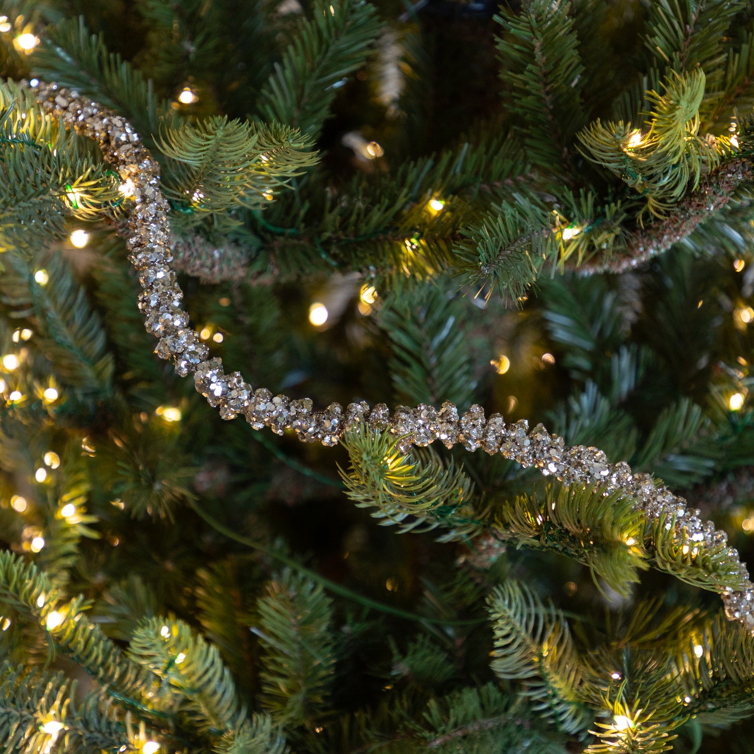 Champagne Glitter Garland on a lit Christmas tree.