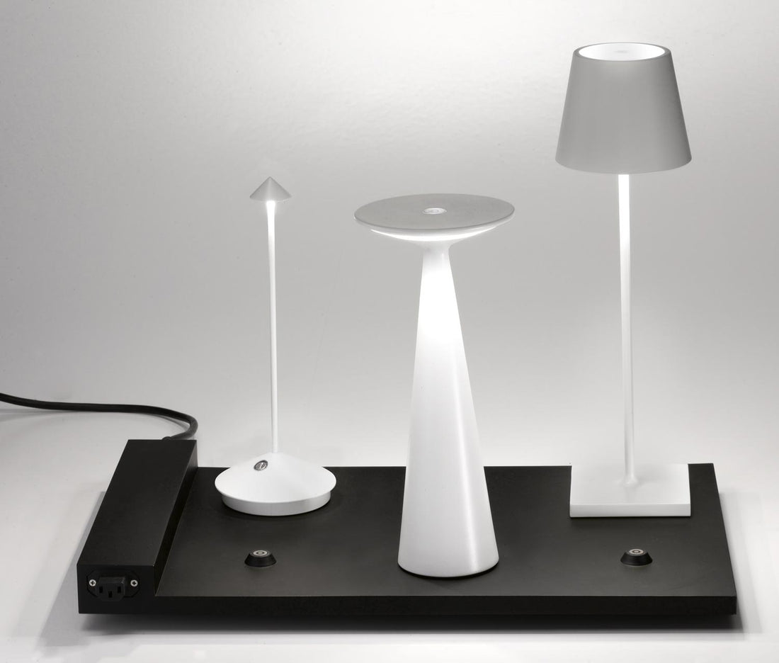 A modern black cordless desk lamp with a unique flat base, including a modular charging system and spherical bulbs on a white background from Zafferano&