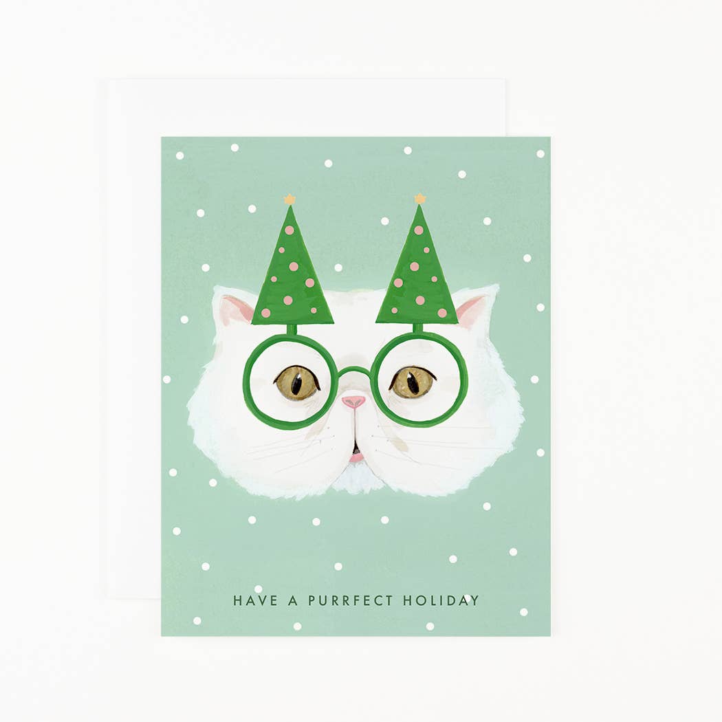 A Dear Hancock Purrfect Holiday Card featuring a hand-painted illustration of a white cat wearing green glasses and a pair of party hats resembling Christmas trees, with the pun &quot;have a purrfect holiday&quot; written below.