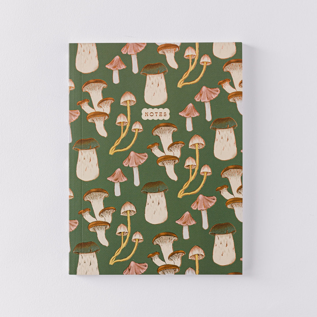 front of green note book with mushroom illustrations on it. 