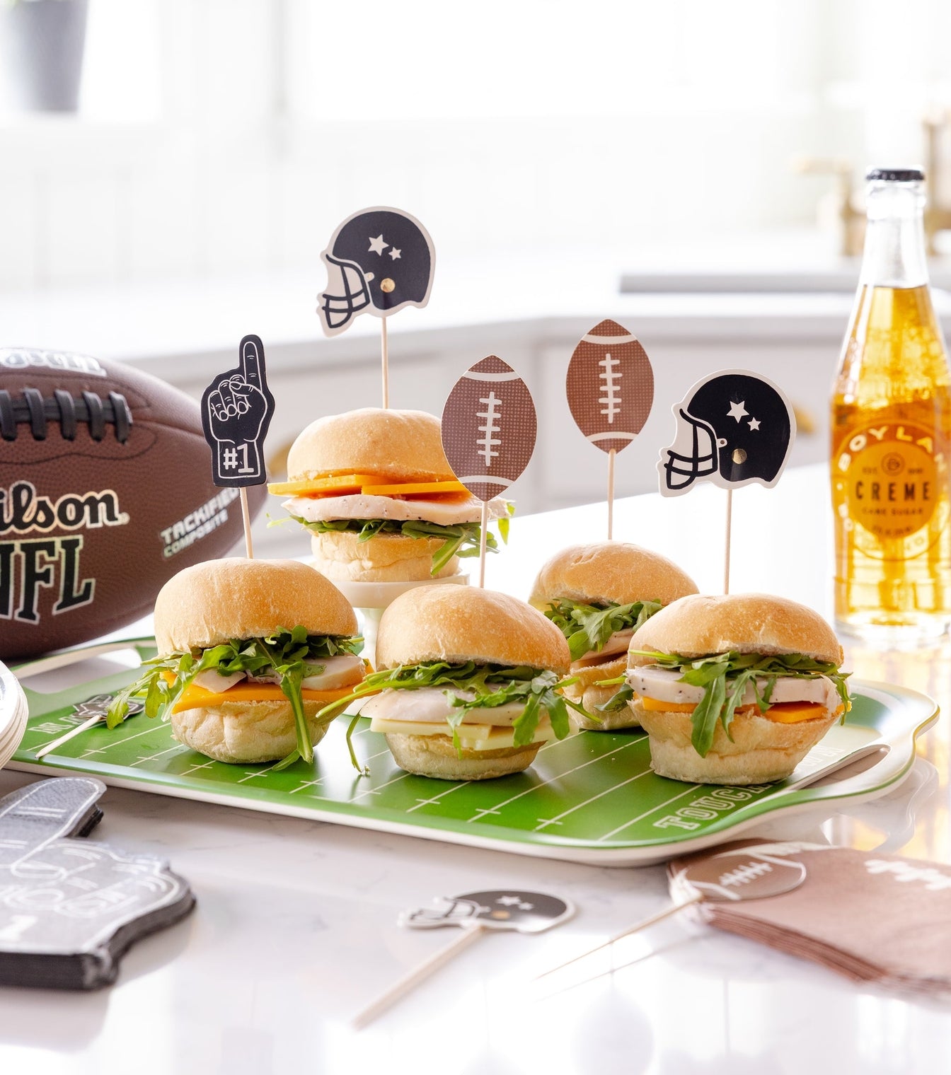 Football themed food picks shown in various food for a football party. 