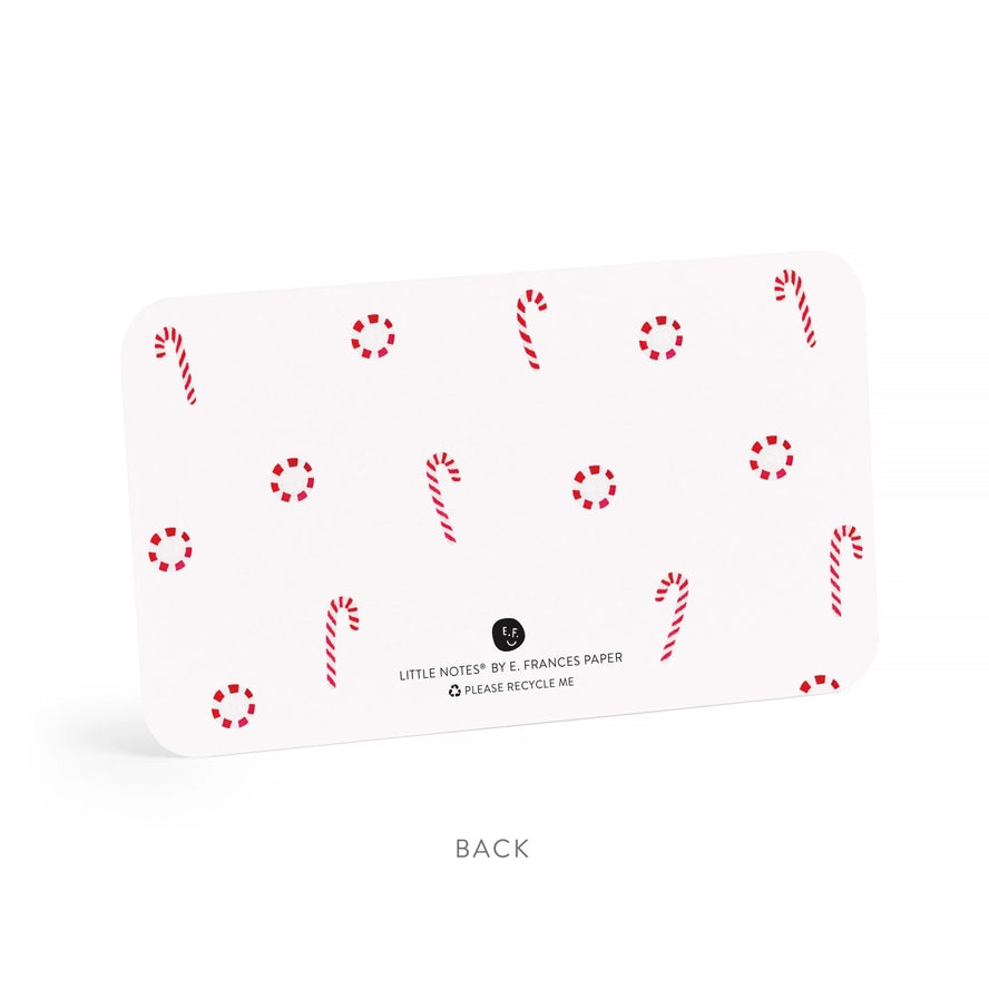 A white rectangular card with rounded corners, shown from the back on a white background. The card has a scattered red and white holiday pattern of candy canes and dotted circles, with small black text reading &