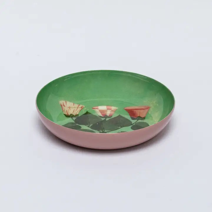 A green enamel plate with illustrated pink florals on a white background.