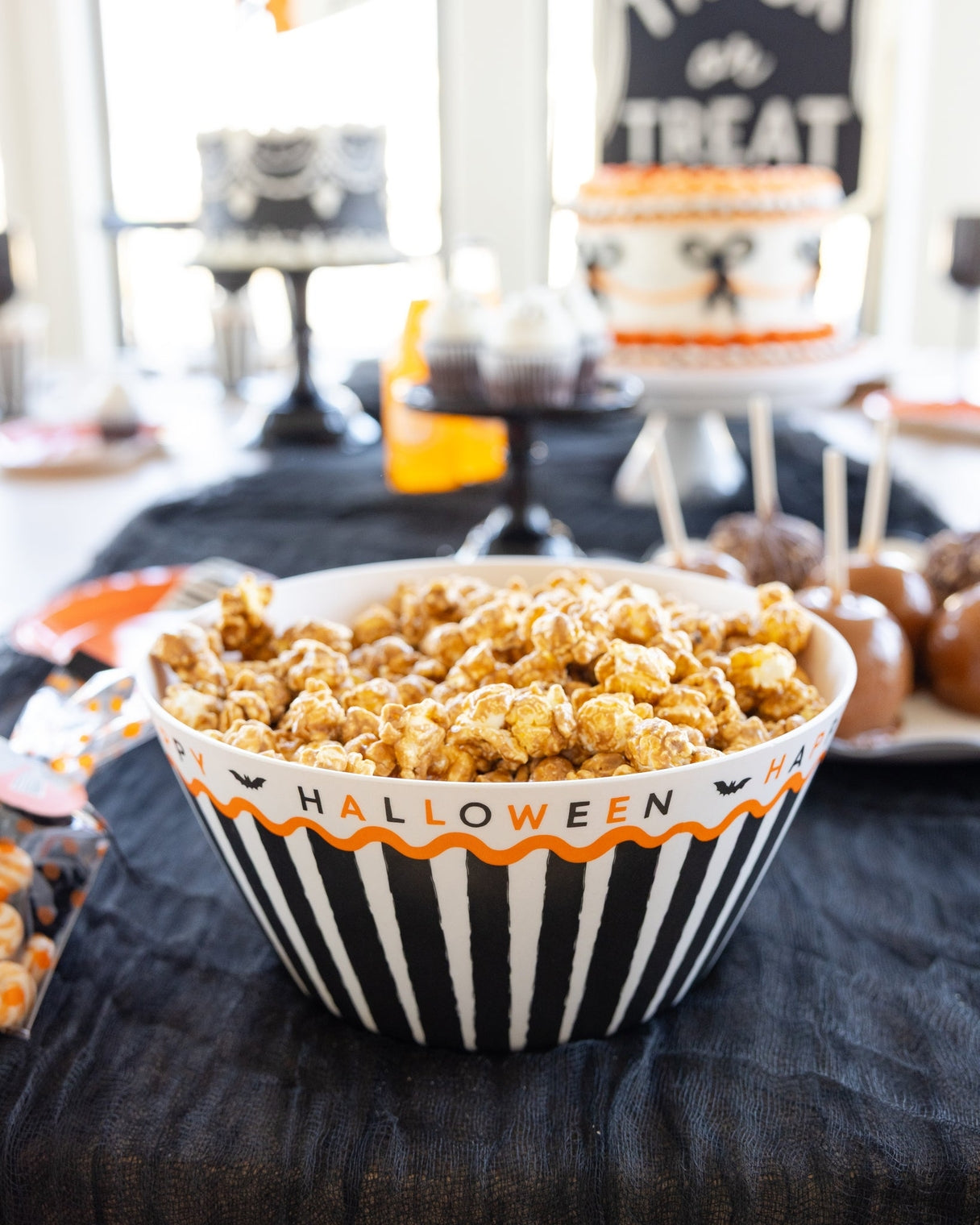 Halloween-themed bowl filled with popcorn on a table with festive decorations.