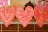 Three heart-shaped decorative garland with floral patterns on a shelf.