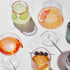 Four assorted Prohibition-era cocktails in elegant glasses, garnished with fruit slices and set on a marble surface with W&P Ice Cube Trays.