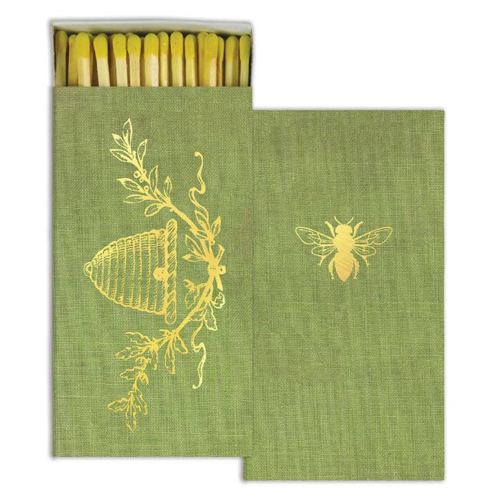 Green matchbox with yellow bee design on a white background.