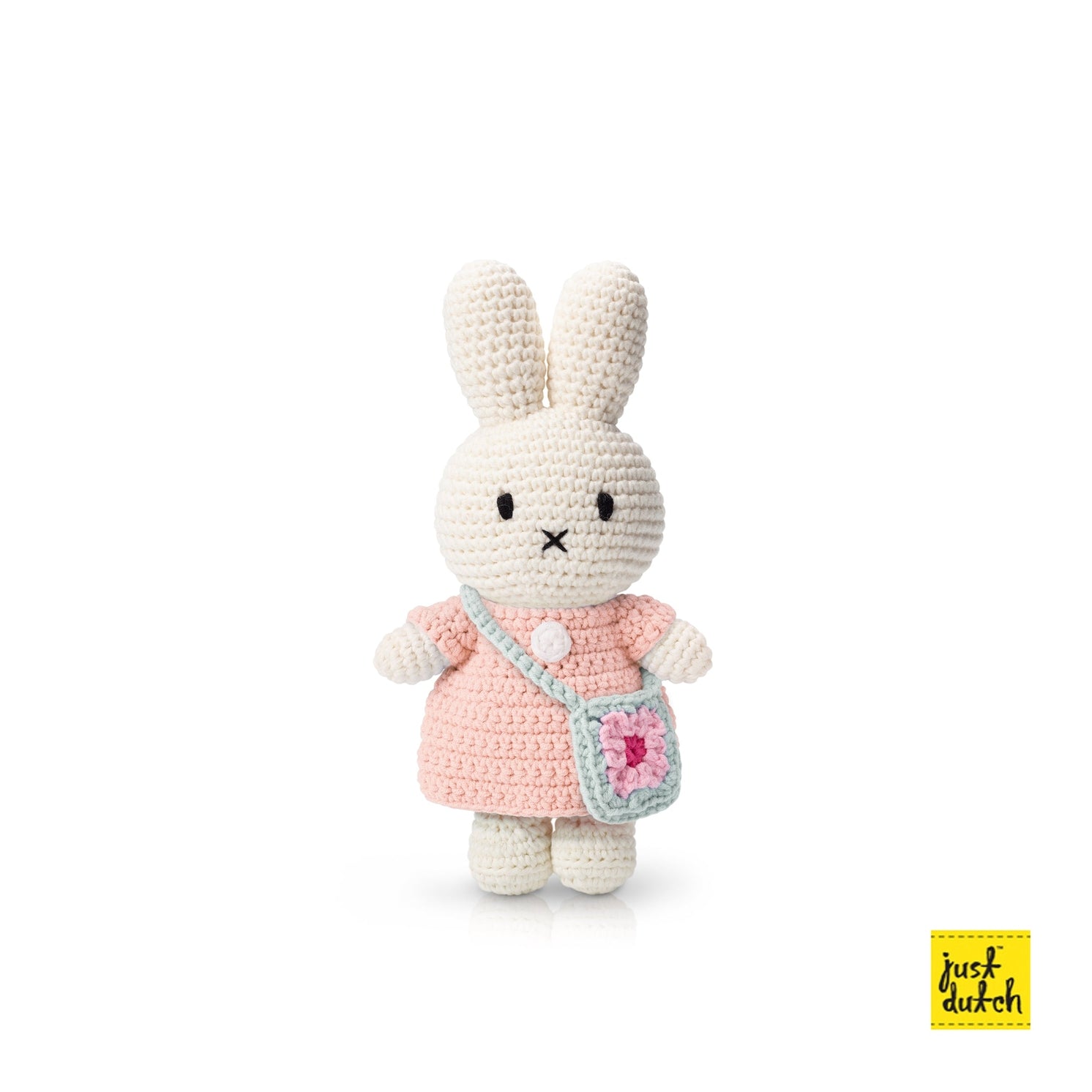 A plush toy resembling a rabbit with a pastel pink dress and a blue flower bag, standing against a white background.