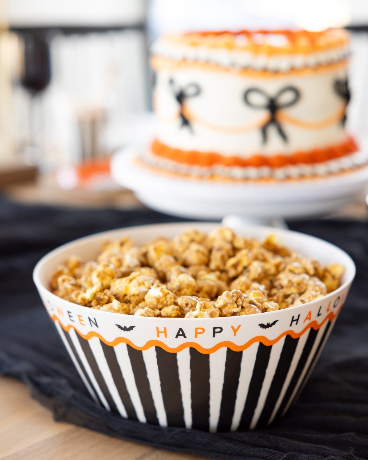 Bowl of popcorn with Halloween-themed design on a black surface.