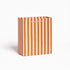 Striped paper gift bag with orange and pink vertical stripes on a white background.