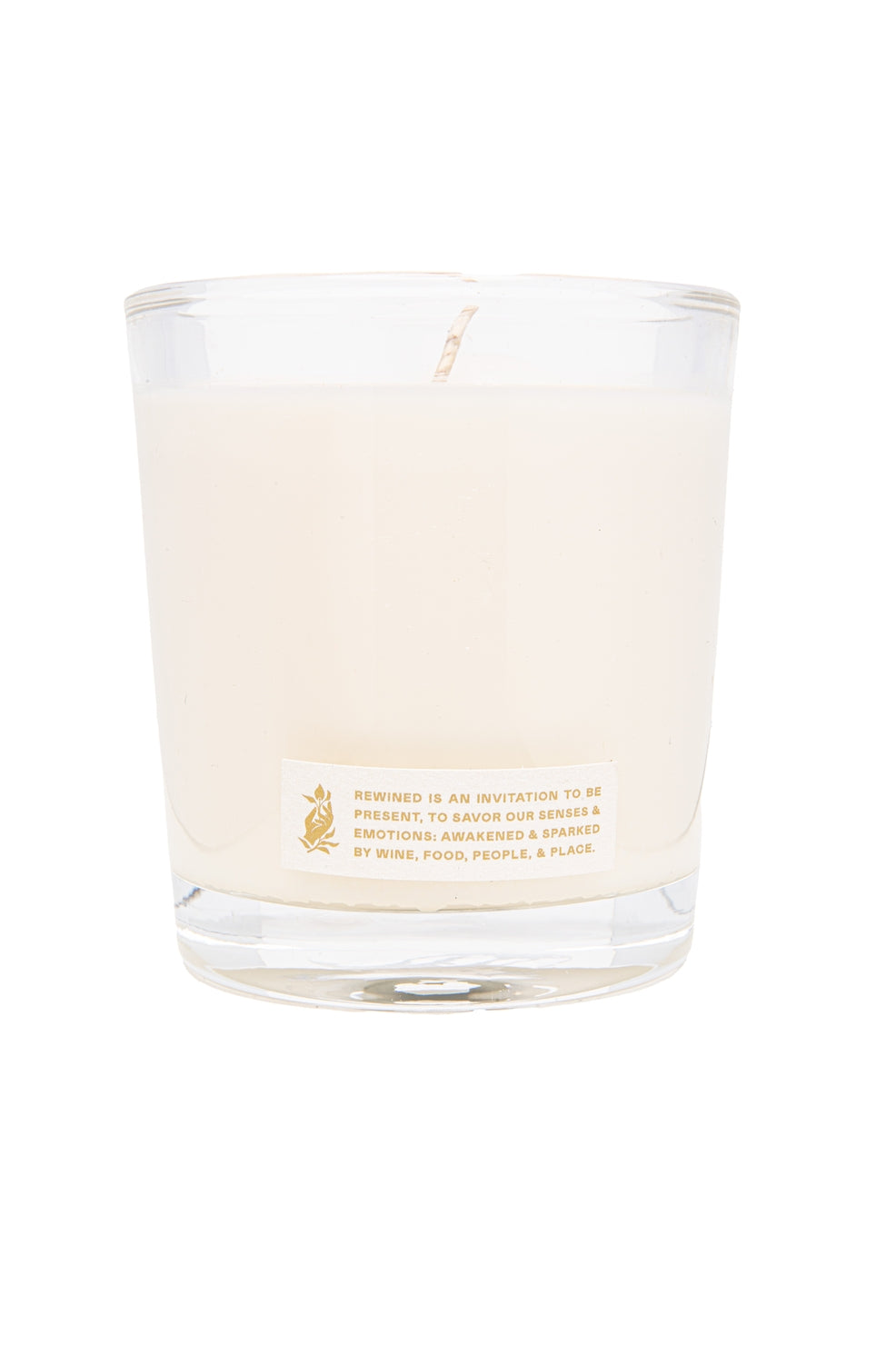 Clear glass candle with a label on a white background.