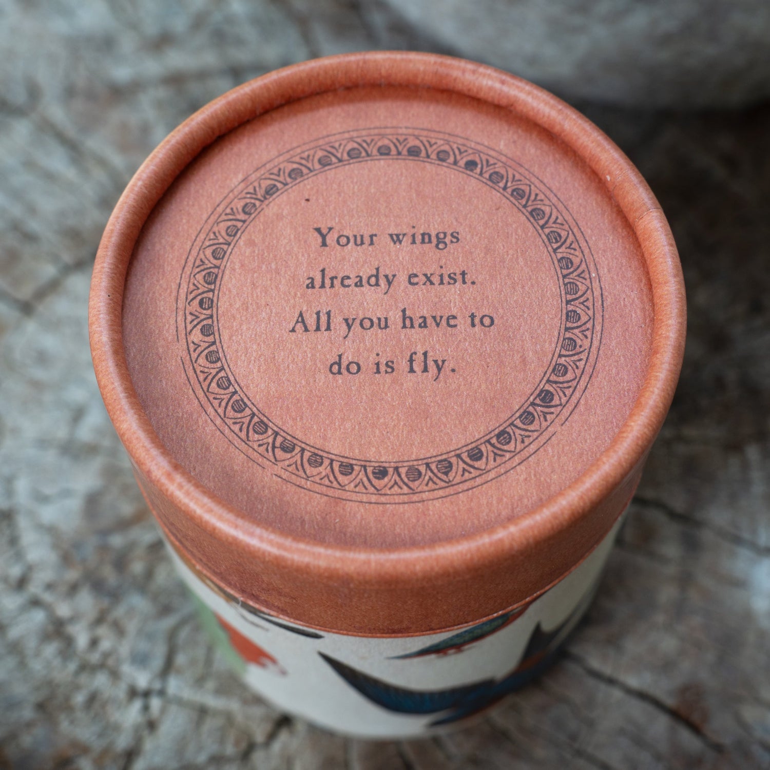 Ceramic container with a motivational quote on a textured surface.