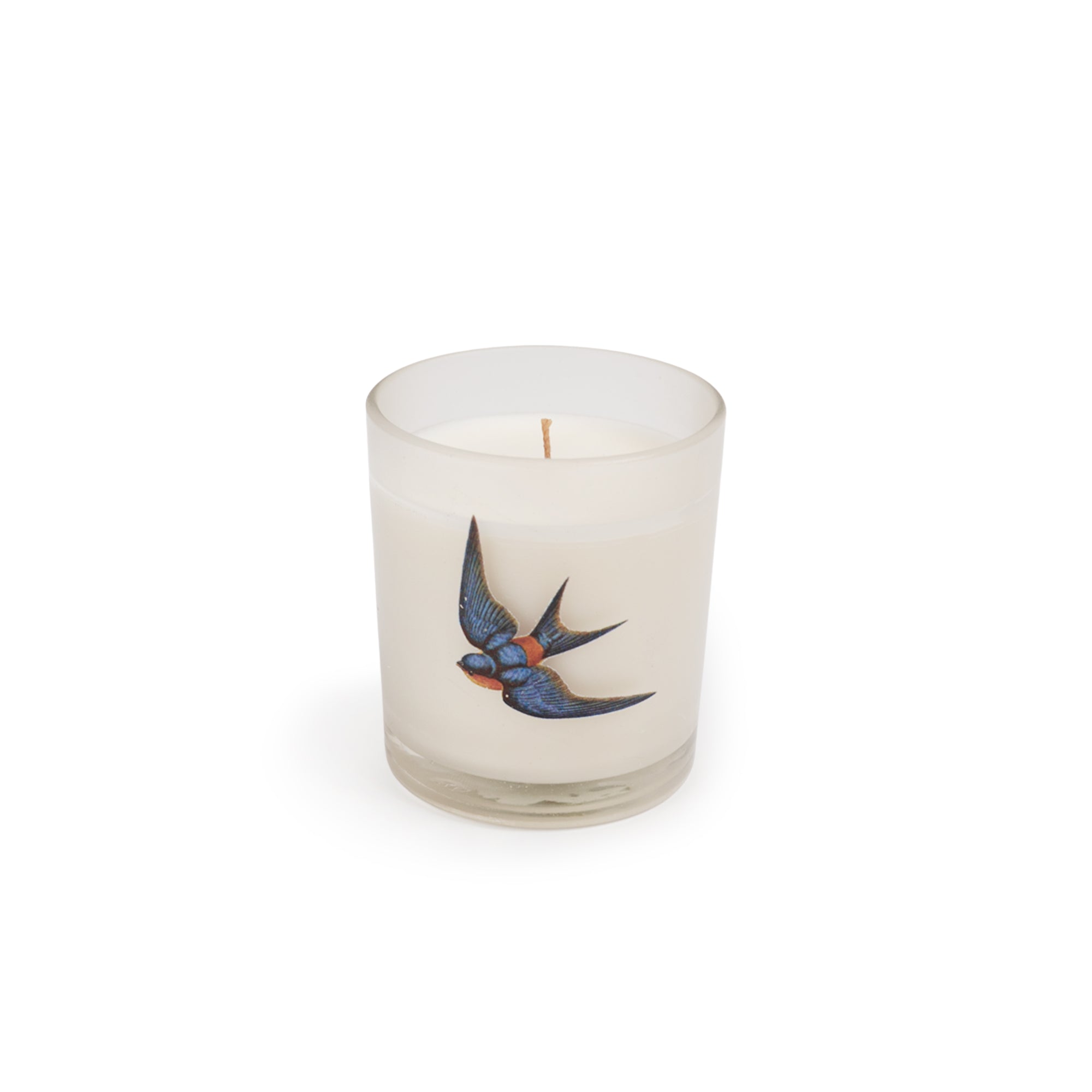 Candle in a glass container with a swallow design on a white background.