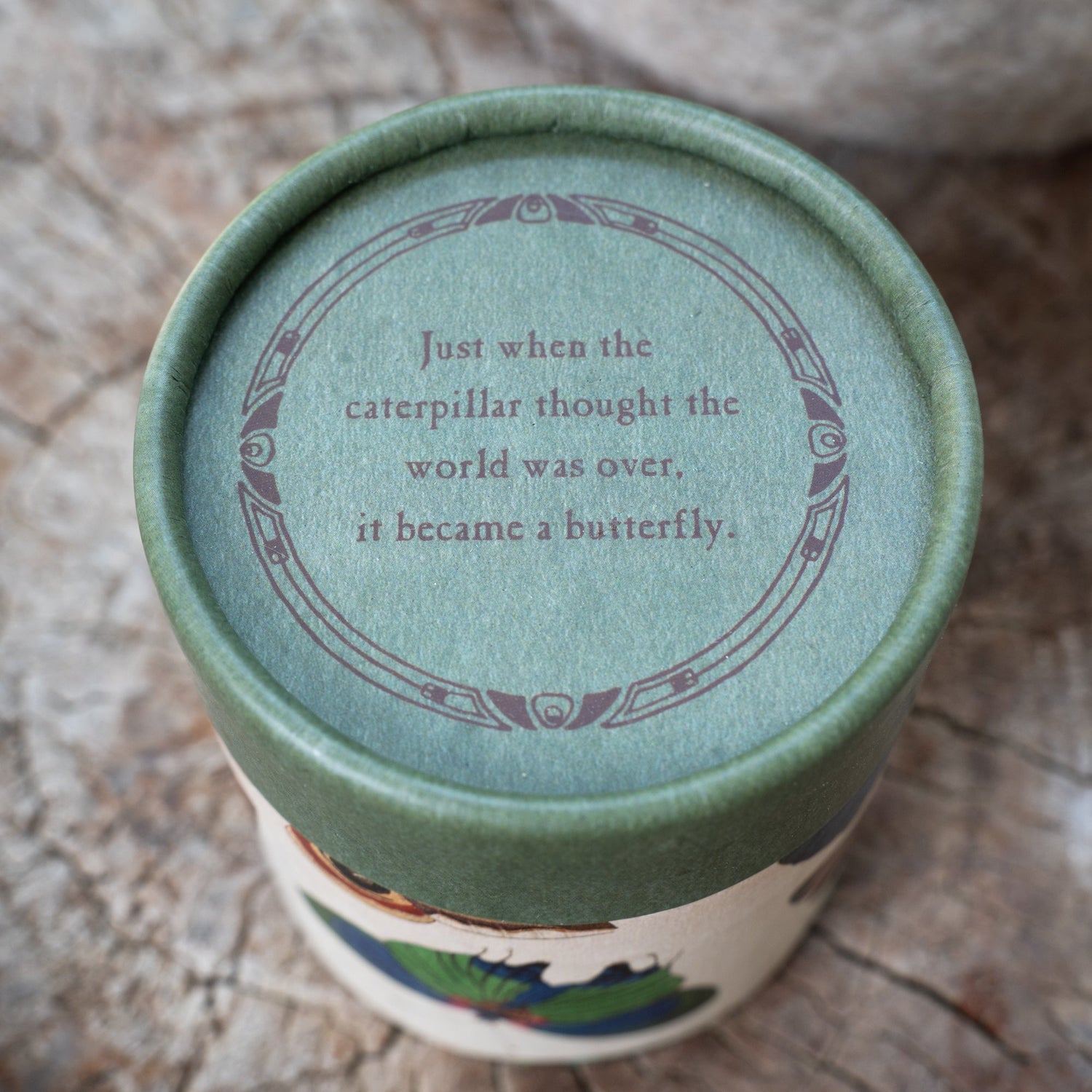 Green container lid with motivational quote on a textured surface.