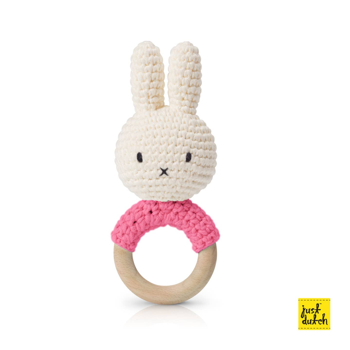 Crocheted bunny rattle with pink wooden ring on a white background.