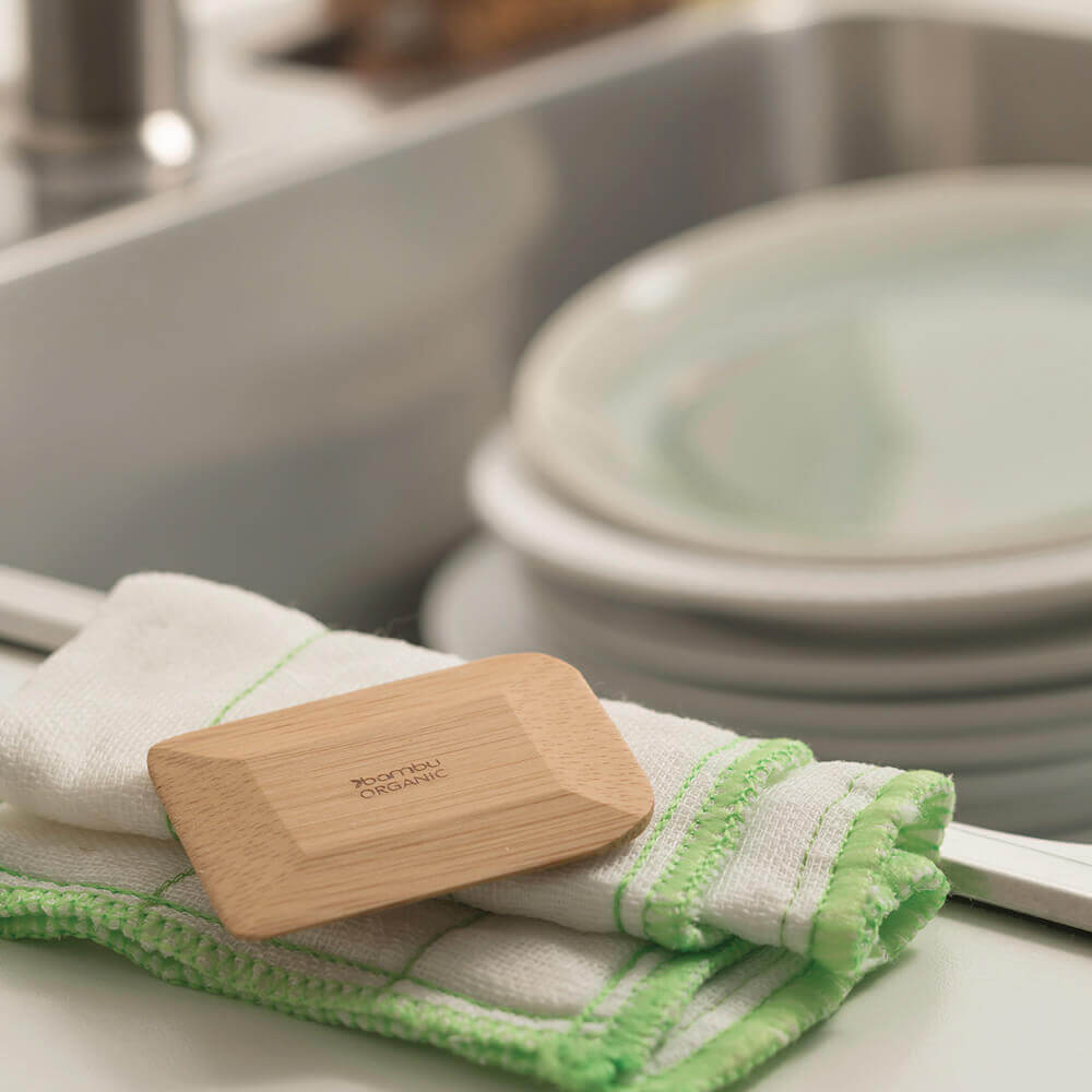  Bamboo scraper on a green and white striped towel with a kitchen sink in the background