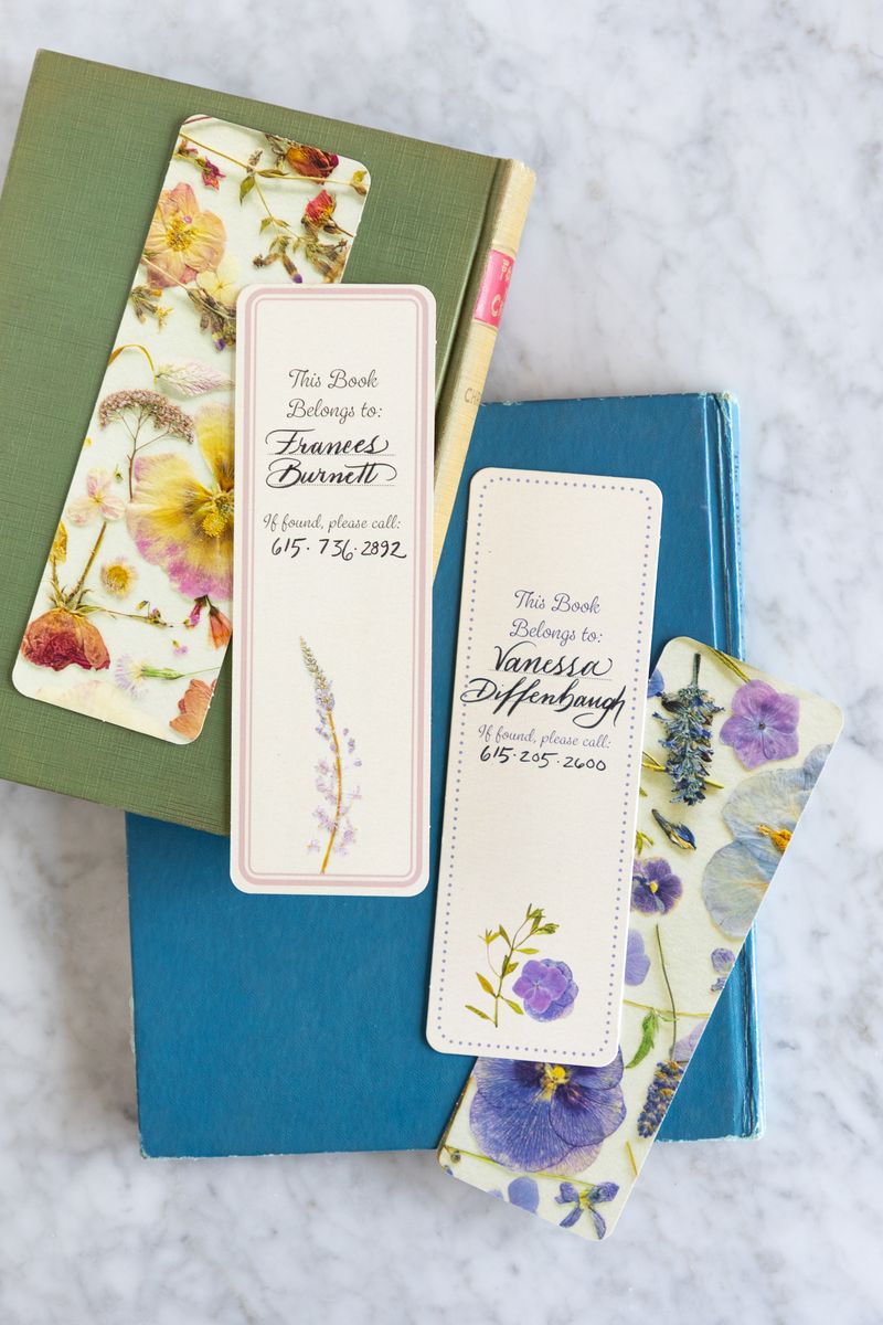 Floral bookmarks on books with personalized text on a light gray background