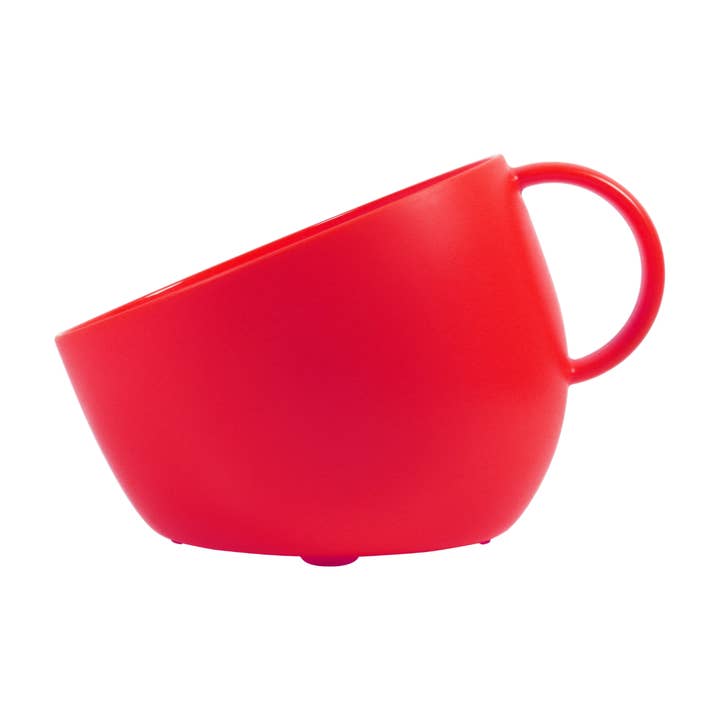 A bright red mug shaped dog bowl with a matching red handle, shown at an angle on a plain white background.