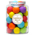 A clear glass jar filled with multicolored miniature surprise balls, each a different color, with a label on the jar reading &