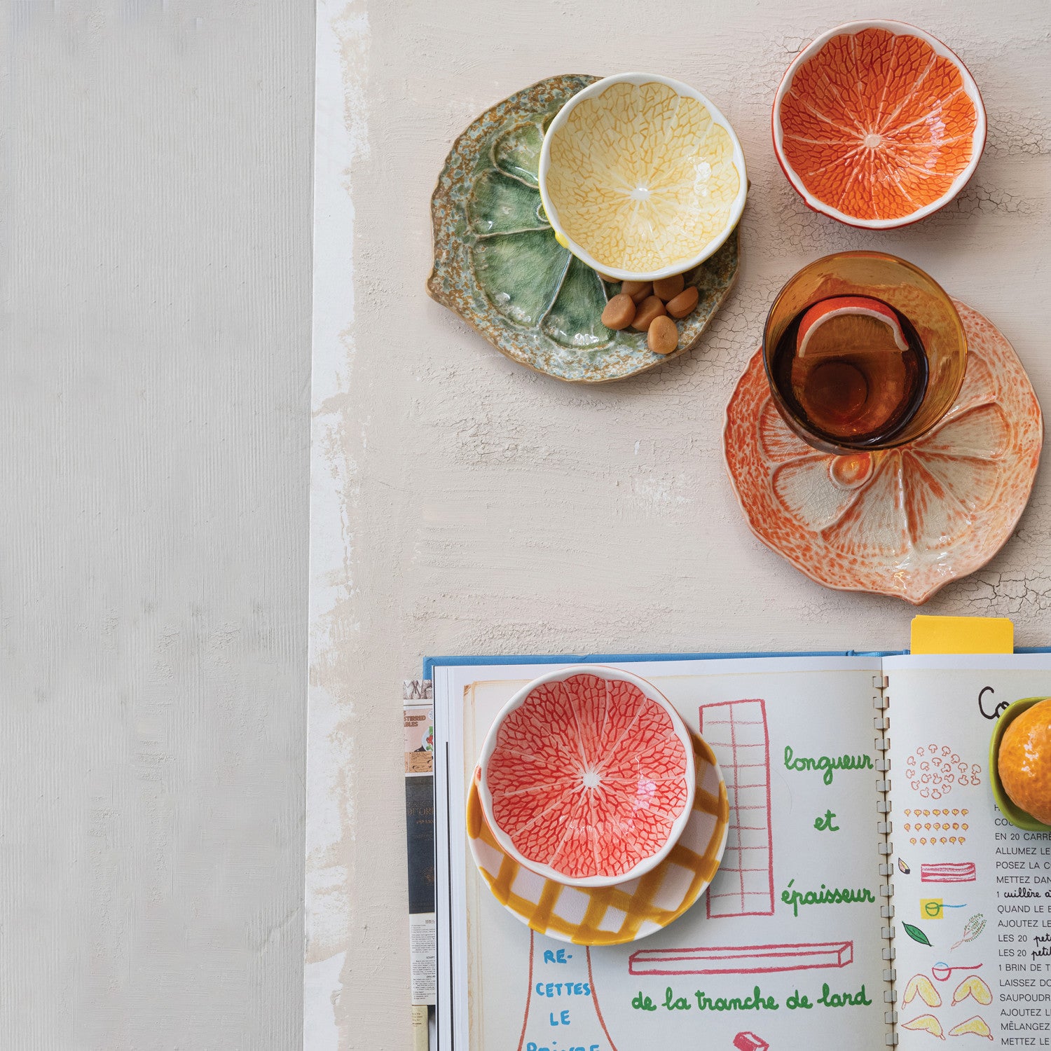 Open book with illustrations of a sliced grapefruit and other fruits on a table.