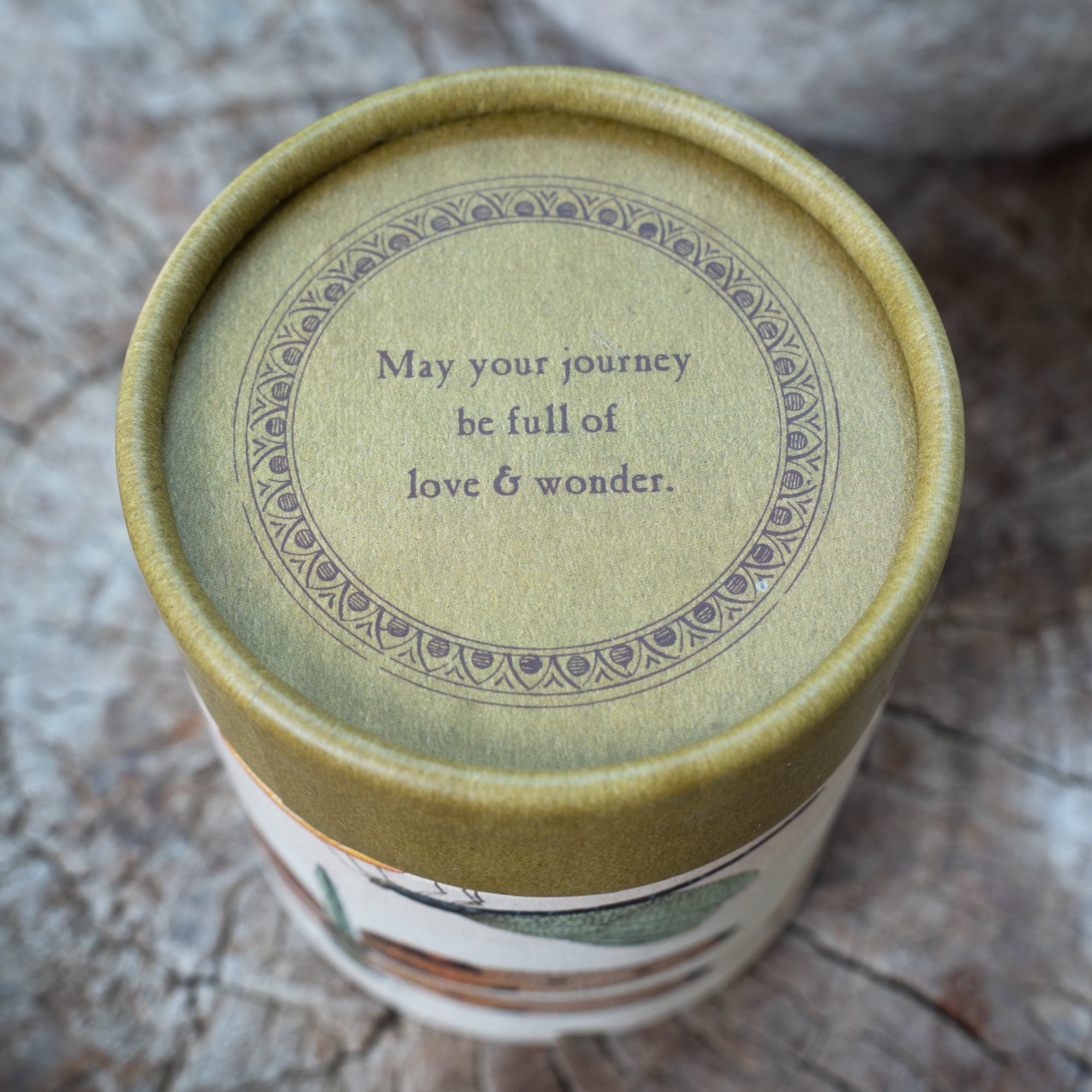 Ceramic container with a motivational quote on a textured surface.