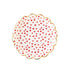 A white scalloped plate with small red hearts printed on it.