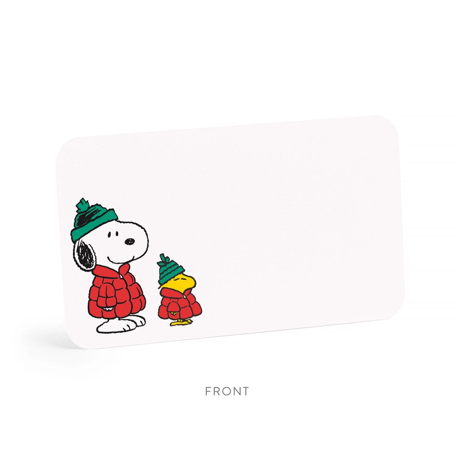 A white rectangular desk organizer or card holder with rounded corners, featuring a printed illustration of Snoopy and Woodstock wearing red winter coats and green hats. The word &
