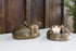 Bronze fox-shaped candle holders on a white surface with a wooden background.