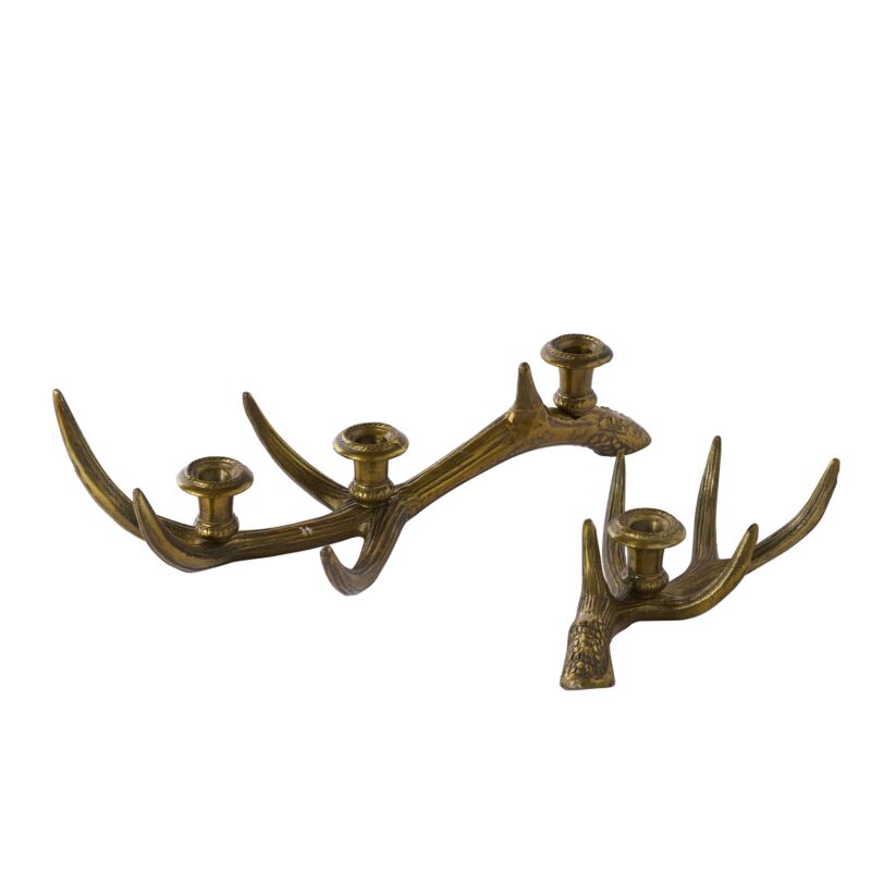Two decorate brass antler candle holders against a white background, one larger and with three places for candles, the other with just one. 