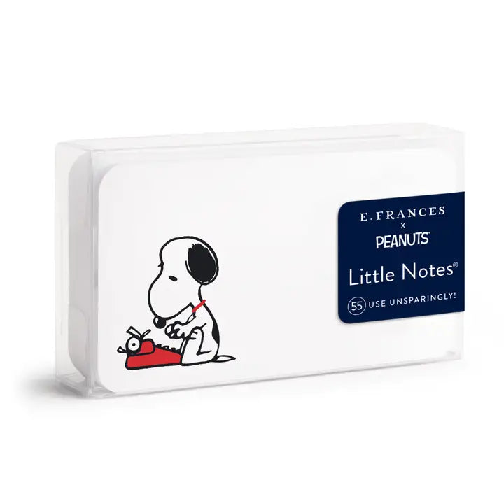 E. Frances x Peanuts Little Notes notebook in a clear plastic case, featuring a black and white cartoon drawing of Snoopy and a red typewriter on a white cover, with a navy blue product label on the right.