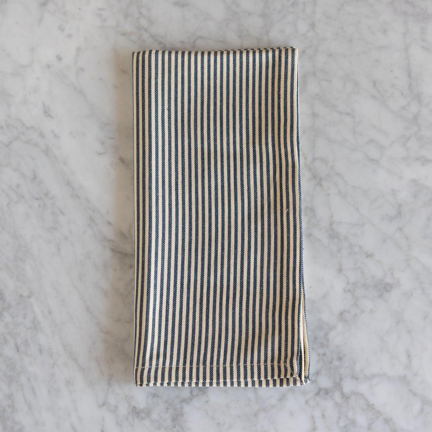 Striped fabric napkin on a marble surface. 