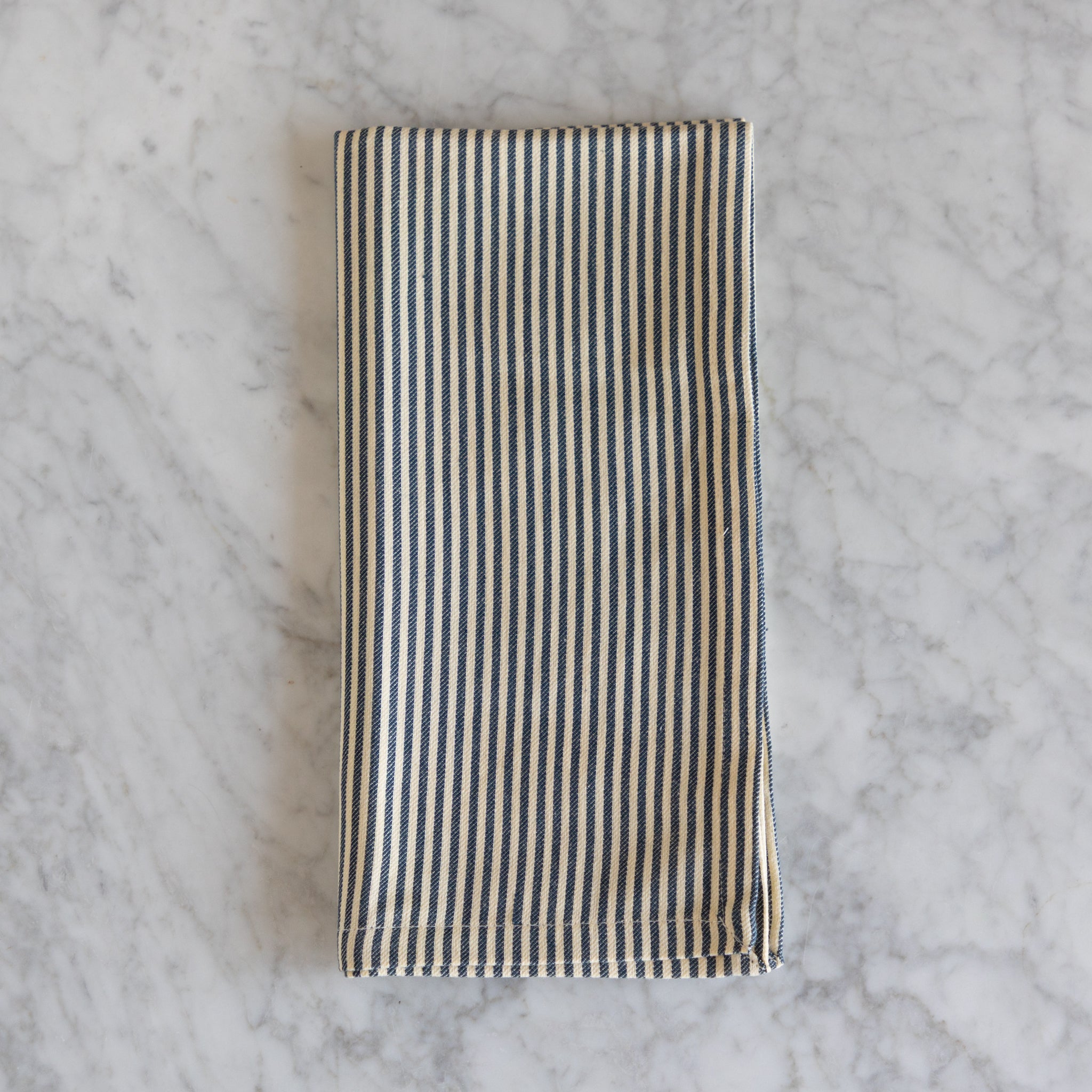 Striped fabric napkin on a marble surface. 