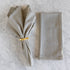 Striped napkin with a gold ring on a marble surface.