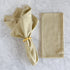 Striped napkin with a gold ring on a marble surface.
