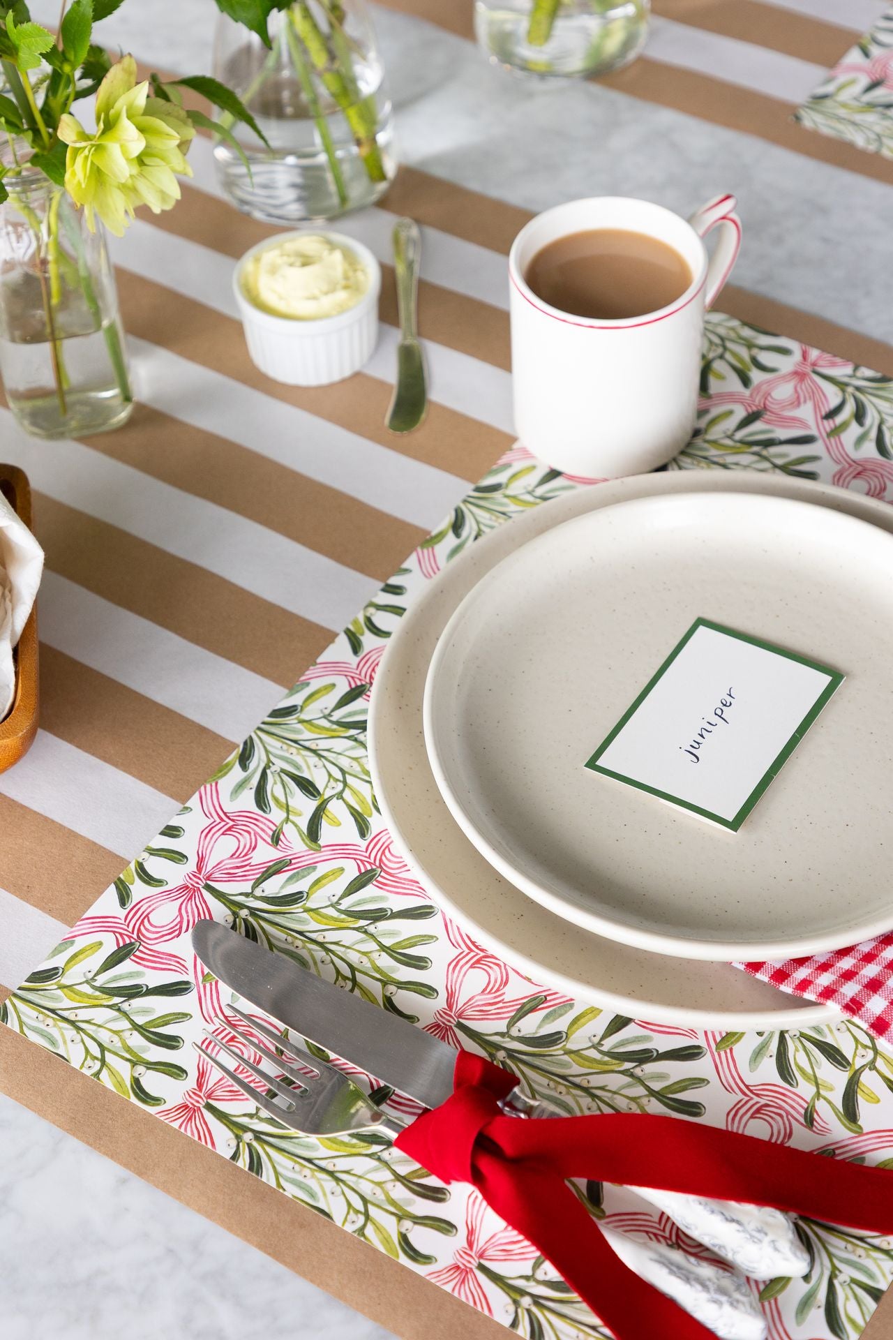 A holiday place setting with the fork and knife tied with soft red ribbon.