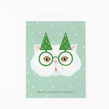 A Dear Hancock Purrfect Holiday Card featuring a hand-painted illustration of a white cat wearing green glasses and a pair of party hats resembling Christmas trees, with the pun &quot;have a purrfect holiday&quot; written below.