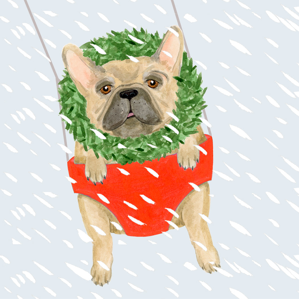 A hand painted frenchie wearing a wreath in a swing with snow